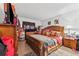 Spacious bedroom with wood furnishings, soft lighting, and a cozy bed with colorful bedding at 2840 Somerset Park Dr # 203, Tampa, FL 33613