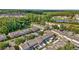 An aerial view of townhomes by a lush forest and a serene lake, creating a peaceful and scenic neighborhood at 30140 Barnaby Ln, Wesley Chapel, FL 33543