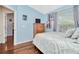 Comfortable bedroom with light-blue walls, wood floors, window with natural light, and closet at 30140 Barnaby Ln, Wesley Chapel, FL 33543