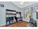Bedroom features desk area, built-in shelves, hardwood floors and natural light at 30140 Barnaby Ln, Wesley Chapel, FL 33543