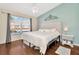 This bedroom features a large window, hardwood floors, and a ceiling fan at 30140 Barnaby Ln, Wesley Chapel, FL 33543