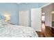 Inviting bedroom features light-blue walls, hardwood floors, closet and ensuite bathroom at 30140 Barnaby Ln, Wesley Chapel, FL 33543
