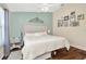 This bedroom has a large decorative headboard, hardwood floors, and a ceiling fan at 30140 Barnaby Ln, Wesley Chapel, FL 33543