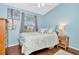 Bright bedroom features blue walls, hardwood floors, a ceiling fan and comfortable decor at 30140 Barnaby Ln, Wesley Chapel, FL 33543
