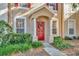 Charming townhome front door with red door, wreath and small front garden at 30140 Barnaby Ln, Wesley Chapel, FL 33543