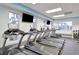 Modern gym featuring treadmills with individual screens and large windows for natural light at 30140 Barnaby Ln, Wesley Chapel, FL 33543