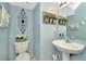 Stylish half bath with blue walls, pedestal sink, and decorative accents at 30140 Barnaby Ln, Wesley Chapel, FL 33543