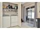 Bright laundry area with tiled floor, front load washer/dryer, storage and sliding door to screened porch at 30140 Barnaby Ln, Wesley Chapel, FL 33543