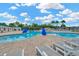 Beautiful community pool with ample lounge seating, palm trees, and clear blue water at 30140 Barnaby Ln, Wesley Chapel, FL 33543