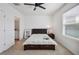 Bedroom with ceiling fan, carpet flooring, and a large window, leading to bathroom at 32965 Kaloko Rd, Wesley Chapel, FL 33543
