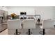 Modern kitchen island with bar stool seating, granite countertops, and stainless steel appliances at 32965 Kaloko Rd, Wesley Chapel, FL 33543