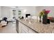 Modern kitchen with a large granite island overlooking a comfortable living space and natural light at 32965 Kaloko Rd, Wesley Chapel, FL 33543