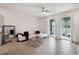Bright living room featuring sliding glass doors, stylish white sofa, and neutral decor at 32965 Kaloko Rd, Wesley Chapel, FL 33543