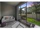 Enclosed patio with outdoor seating, glass table, and view of the lawn and neighborhood at 32965 Kaloko Rd, Wesley Chapel, FL 33543