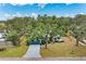 An aerial view of a quaint single-story home surrounded by lush greenery and mature shade trees at 3330 46Th E Ter, Bradenton, FL 34203