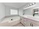 Bright bathroom featuring double vanity, soaking tub and glass block window at 3330 46Th E Ter, Bradenton, FL 34203