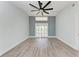 Spacious bedroom featuring new wood-look flooring, large ceiling fan, and sliding glass door at 3330 46Th E Ter, Bradenton, FL 34203