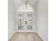 Inviting foyer featuring a decorative chandelier and glass paneled front door, with new wood-look flooring at 3330 46Th E Ter, Bradenton, FL 34203