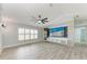 Open living room with wood floors, ceiling fan, and accent wall with large screen television at 3330 46Th E Ter, Bradenton, FL 34203