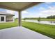 Covered back porch that shows the outdoor living space with views of the waterfront and landscaping at 35609 Stableton Lane, Zephyrhills, FL 33541