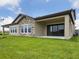 View of the home's exterior with a well-maintained lawn and covered patio, perfect for outdoor living at 35609 Stableton Lane, Zephyrhills, FL 33541