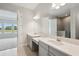 Bathroom featuring dual sinks, quartz countertops, and a large mirror at 35609 Stableton Lane, Zephyrhills, FL 33541