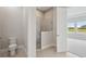 Bright bathroom featuring tiled shower with glass enclosure and a modern toilet at 35609 Stableton Lane, Zephyrhills, FL 33541