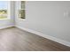 Bright bedroom with wood floors and a view of the outdoors through two windows at 35609 Stableton Lane, Zephyrhills, FL 33541