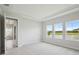 Bright bedroom featuring plush carpeting and views of the community pond at 35609 Stableton Lane, Zephyrhills, FL 33541