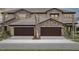 Attractive townhouse showcasing a stone facade and two-car garage, creating a modern and inviting exterior at 35609 Stableton Lane, Zephyrhills, FL 33541