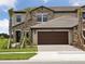 Charming townhouse featuring a spacious garage and well-manicured lawn, offering a welcoming curb appeal at 35609 Stableton Lane, Zephyrhills, FL 33541
