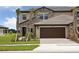 Charming home with stone accents, a tandem garage, and a beautifully landscaped front yard at 35609 Stableton Lane, Zephyrhills, FL 33541