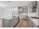 Bright, open kitchen featuring gray cabinets, stainless steel appliances, and a spacious island at 35609 Stableton Lane, Zephyrhills, FL 33541