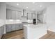Modern kitchen featuring gray cabinets, stainless steel appliances, and an island with a white countertop at 35609 Stableton Lane, Zephyrhills, FL 33541