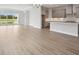 Open-concept living room and kitchen with wood floors and a view of the lake through sliding glass doors at 35609 Stableton Lane, Zephyrhills, FL 33541