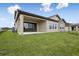 Backyard with a covered patio, windows and green lawn at 35617 Stableton Lane, Zephyrhills, FL 33541