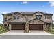 A beautiful townhouse featuring a stone facade and two-car garage with brick paver driveway at 35617 Stableton Lane, Zephyrhills, FL 33541