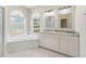 Beautiful bathroom with marble countertops, soaking tub and arched windows at 3610 Woodbridge Ave, North Port, FL 34287