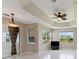 Spacious bedroom with tray ceiling, fan, and view of backyard through large windows at 3610 Woodbridge Ave, North Port, FL 34287