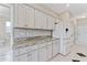 Bright kitchen features white cabinets, granite countertops, tiled backsplash, and stainless-steel appliances at 3610 Woodbridge Ave, North Port, FL 34287