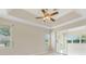 Main bedroom showcasing a tray ceiling, fan, tile flooring, and multiple windows at 3610 Woodbridge Ave, North Port, FL 34287