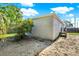 View of the back of the home with a small porch and sandy area at 3708 N 56Th St, Tampa, FL 33619