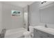 Bright bathroom features a shower-tub combo, modern vanity, and neutral tile at 3708 N 56Th St, Tampa, FL 33619