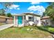 Charming home featuring a bright teal front door and a well-maintained lawn at 3708 N 56Th St, Tampa, FL 33619