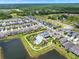 Stunning aerial view of a community featuring a lake, pool, clubhouse, and perfectly landscaped lawns at 3952 Almond Brook Blvd, Land O Lakes, FL 34638