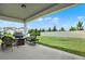 View of the backyard featuring well-maintained lawn, barbecue grill, and white fence at 3952 Almond Brook Blvd, Land O Lakes, FL 34638
