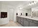 Elegant bathroom with double sinks, quartz countertops, modern lighting, and a glass-enclosed shower at 3952 Almond Brook Blvd, Land O Lakes, FL 34638