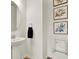 Cozy half bathroom featuring a pedestal sink, oval mirror and floral wall art at 3952 Almond Brook Blvd, Land O Lakes, FL 34638