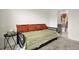 Neutral-toned bedroom with a daybed, orange pillows, and a small accent table at 3952 Almond Brook Blvd, Land O Lakes, FL 34638