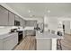 Modern kitchen with gray cabinets, stainless appliances, large island, and open layout at 3952 Almond Brook Blvd, Land O Lakes, FL 34638